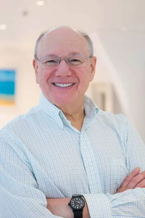 Dr. Robert W. Baritz smiling with arms crossed