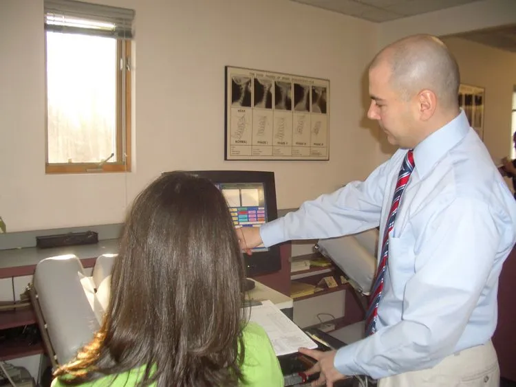 Doctor with a patient beside the X-ray viewer
